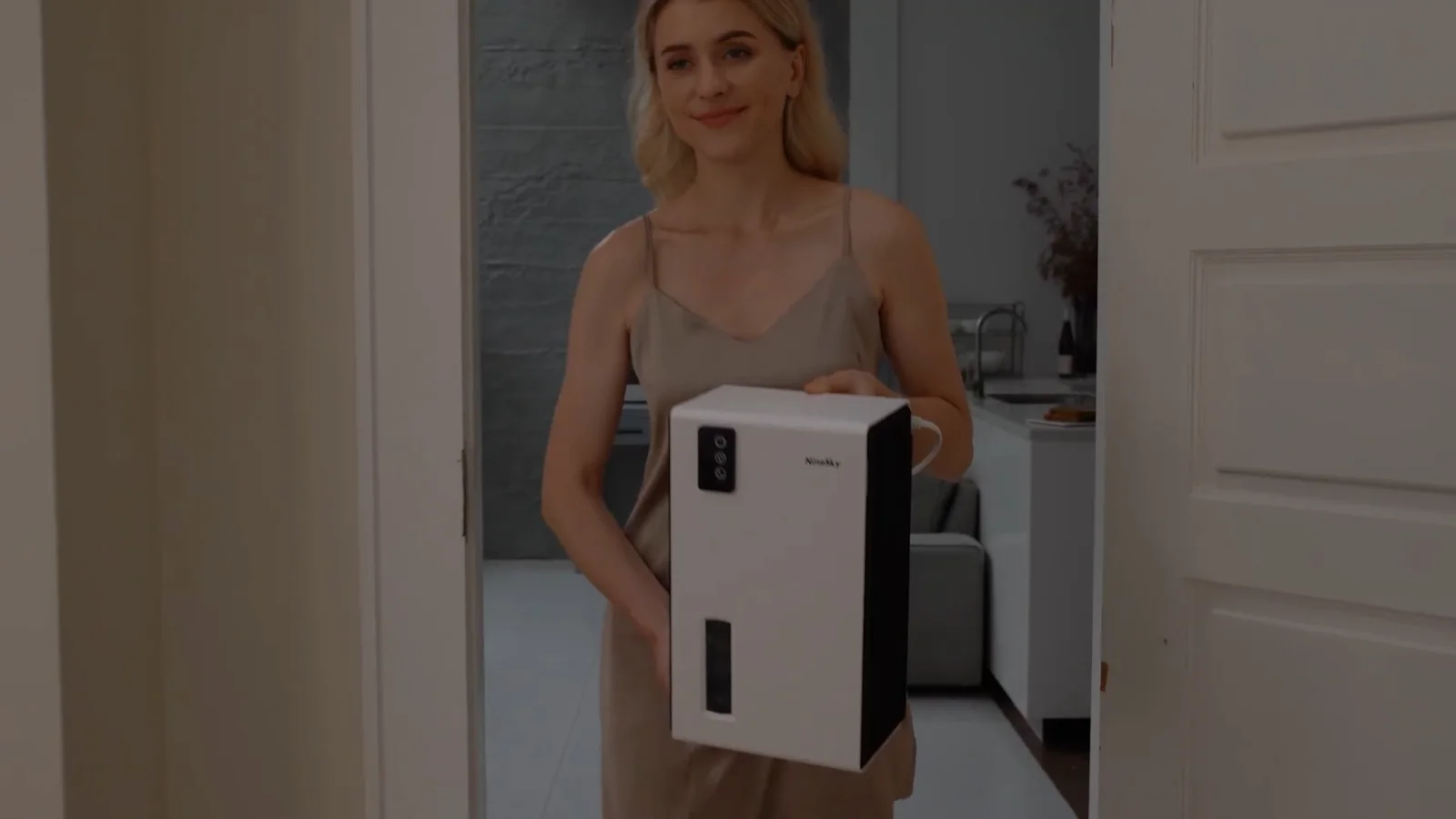 A NineSky CT2 dehumidifier being carried between rooms